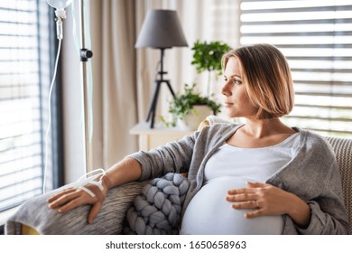 A Portrait Of Pregnant Woman With IV Drip Indoors At Home Or In Hospital.