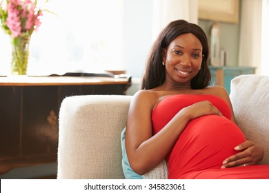 Portrait Of Pregnant Woman Relaxing On Sofa At Home