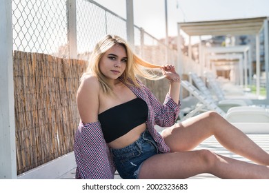 portrait of pret woman sitting on wooden chair, enjoy summer hot sunny day - Shutterstock ID 2002323683