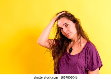 portrait of pretty 25 years old real girl without makeup posing looking at camera isolated on yellow studio background.