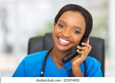 Portrait Of Pretty African American Female Nurse Using Landline Phone