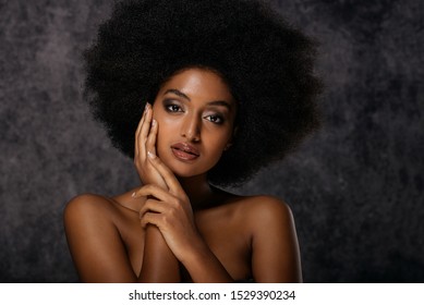 Portrait of pretty afro american woman in a studio for a beauty session - Beautiful girl posing on colored background - Powered by Shutterstock