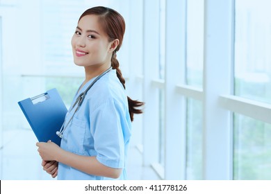 Portrait of pretty Asian nurse with folder