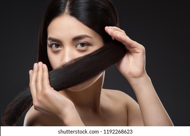 Portrait Of Pretty Asian Woman With Healthy And Strong Hair Isolated On Black