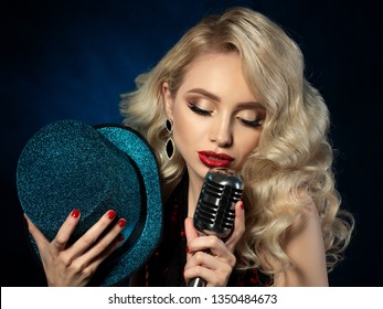 Portrait of pretty blond female singer holding microphone
