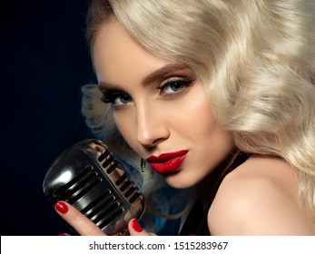 Portrait of pretty blond female singer holding microphone