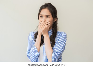 Portrait of pretty brunette hair, disgust smell bad breath strong asian young woman shocked covering, close her mouth with hand, expression face disgusting, dislike odor. Isolated on white background.