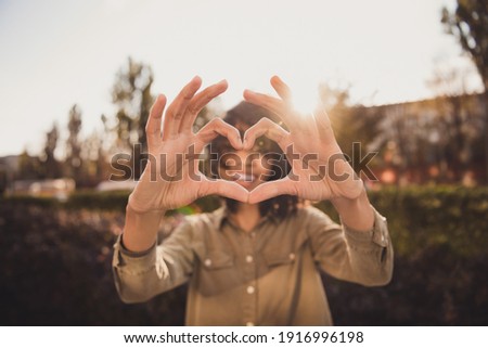 Portrait of pretty cheerful curly hairstyle dark skin lady fingers show heart shape sunny weekend day outdoors