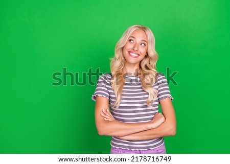 Portrait of pretty cheerful minded person folded hands look empty space isolated on green color background