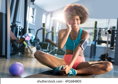 Porträt von hübsch passendem Mädchen in Sportbekleidung mit Balanceball im Fitnessraum