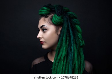 Portrait of a pretty girl with long green dreadlocks.
