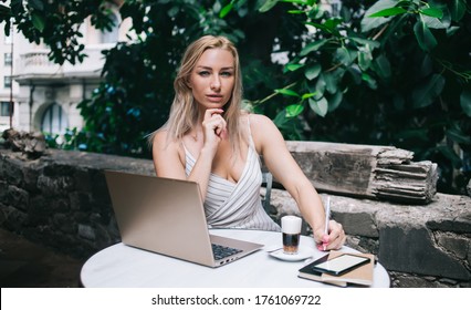 Portrait Of Pretty Laptop User Sitting In Street Cafeteria Spending Time For Doing Distance Job And Planning Business Project, Caucasian Woman 30 Years Old With Modern Netbook Looking At Camera