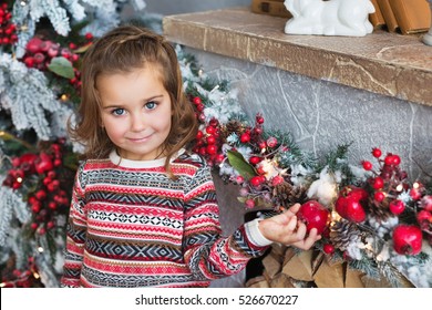 Portrait Of Pretty Little Girl Near A Fireplace In Christmas