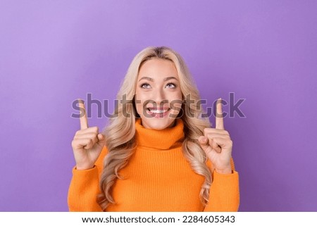 Portrait of pretty positive lady beaming smile look indicate fingers up empty space isolated on purple color background