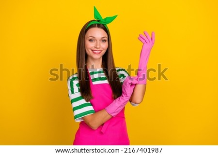Portrait of pretty positive person pit latex gloves hand beaming smile isolated on yellow color background