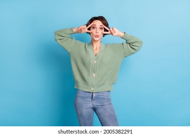 Portrait Of Pretty Positive Person Two Arms Fingers Show V-sign Near Eyes Isolated On Blue Color Background