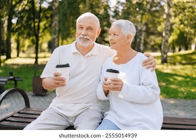 Portrait of pretty senior couple savoring coffee in urban park on sunny summer day, sharing love and warmth, embracing and cherishing simple joys of life. Elderly people enjoying retirement together. - Powered by Shutterstock