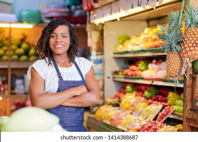 Portrait Of Pretty Smiling Black Saleswoman Standing In Grocery Store With Her Arms Crossed