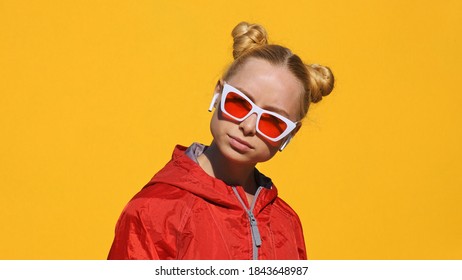 Portrait of pretty teen girl stylish white sunglasses with red glasses raises up, smiling with pleasure on yellow background in summer. Emotions. Positive girl. Lifestyle. Freedom - Shutterstock ID 1843648987