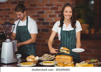 Portrait Of A Pretty Waitress Picking A Sandwich At The Coffee Shop