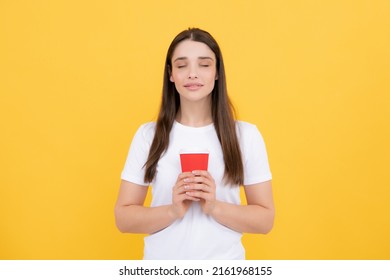 Portrait Of A Pretty Woman Holding Takeaway Coffee Cup Isolated Over Yellow Background.