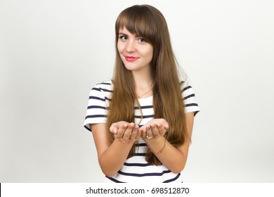 Portrait Of A Pretty Woman Standing Happy Smiling Holding Her Hand Showing Something On The Open Palm, Concept Girl Advertisement Product  Over Gray Background