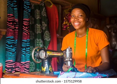 portrait of a pretty young african woman who is a tailor smiling