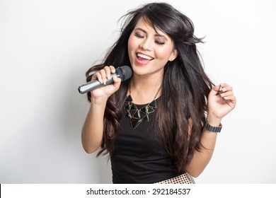 Portrait Of Pretty Young Asian Woman Singing Karaoke With A Mike