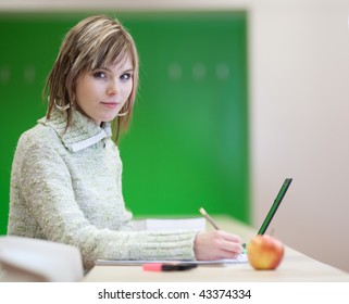 Portrait Of A Pretty Young Blonde College Student Smiling While Taking Notes In A Her College Major Class