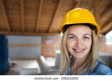 Portrait of pretty young female architect with yellow safety helmet and blue shirt in loft - Powered by Shutterstock