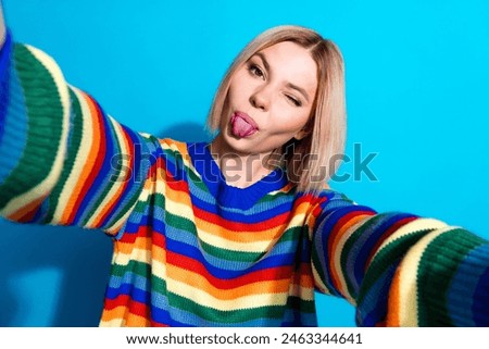 Portrait of pretty young girl make selfie eye wink tongue out wear striped pullover isolated on blue color background
