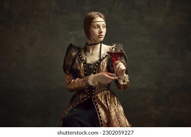 Portrait of pretty, young girl, princess in vintage dress drinking red wine against dark green background. Celebration, degustation. Concept of history, renaissance art remake, comparison of eras