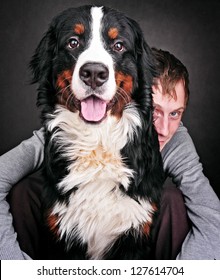 Portrait Of Pretty Young, Happy, Man With  Beautiful Bernese Mountain Dog (Berner Sennenhund)