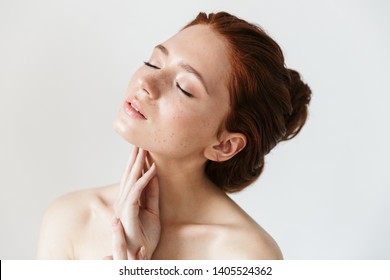 Portrait of a pretty young redhead woman posing isolated over white wall background.