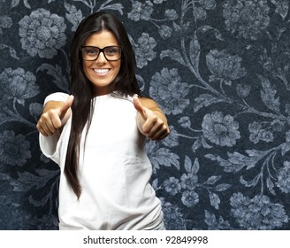 Portrait Of A Pretty Young Woman Doing Good Symbol Against A Vintage Wall