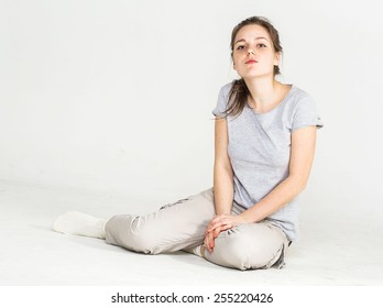 Portrait of a pretty young woman girl sitting on the floor