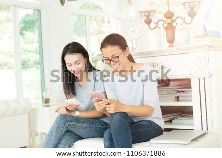 Portrait of pretty young woman lying on sofa and showing funny photos or videos. using mobile app, sharing news, shopping online