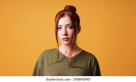 Portrait Of Pretty Young Woman With Red Hair Bun And Curtain Bangs