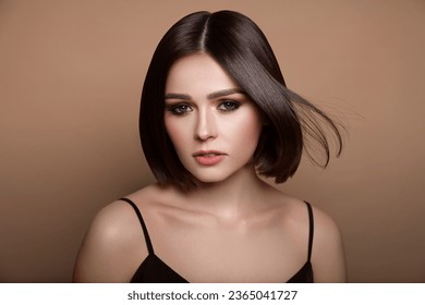 Portrait of pretty young woman with short hair on pastel brown background - Shutterstock ID 2365041727