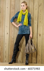 Portrait of pretty young Woman Wearing scarf holding handbag In Studio