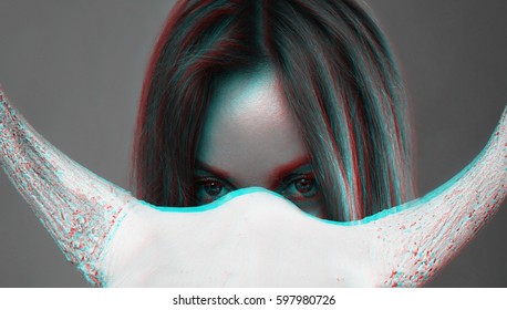 Portrait processed in the style of three-dimensional graphics of a sexy girl with a Slavic appearance peeking out from behind a white skull with horns