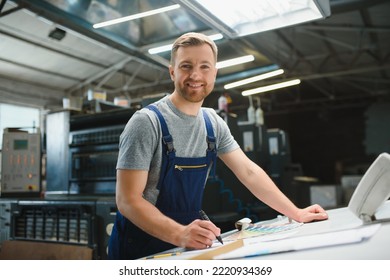 Portrait of production line worker controlling manufacturing process of modern packaging industrial machine in printing factory. - Shutterstock ID 2220934369