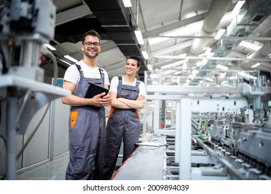 Portrait of production line workers controlling manufacturing process of modern packaging industrial machine in printing factory. - Shutterstock ID 2009894039