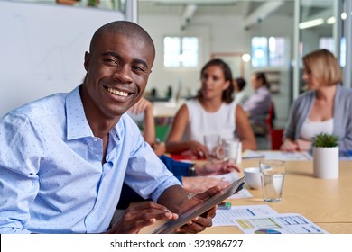 Portrait Of Professional African Black Business Man During Coworkers Boardroom Meeting With Tablet Computer Taking Notes