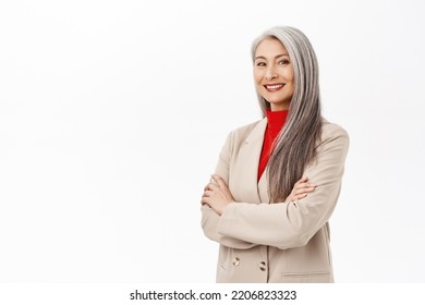 Portrait Of Professional Asian Senior Businesswoman, Cross Arms On Chest, Looking Confident, Wearing Stylish Suit, Smiling Assertive, Working In Corporate, White Background.