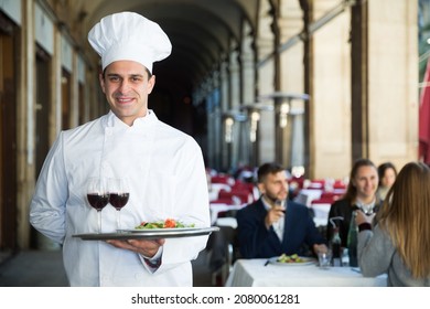 Portrait Of Professional Chef With Serving Tray Meeting Restaurant Guests