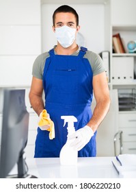 Portrait Of Professional Cleaner Wearing Protective Face Mask And Rubber Gloves Ready For Cleaning In Office