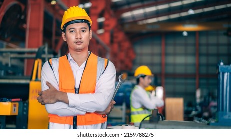Portrait professional confident Asian man industrial engineer,worker,technician with safety hardhat with wrench to maintenance machine for quality control in production steel manufacture factory plant