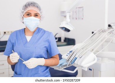 Portrait Of Professional Dentist Woman In Protective Face Mask At Her Workplace In Dental Clinic Office