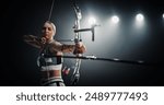 Portrait of Professional Female Archer Aiming an Arrow at a Target with a Compound Bow. Strong Athlete is Fully Equipped and Protected with Chest and Arm Guards, Preparing For Tournament